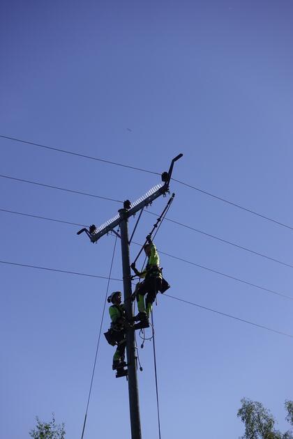 To montører arbeider i toppen av en mast