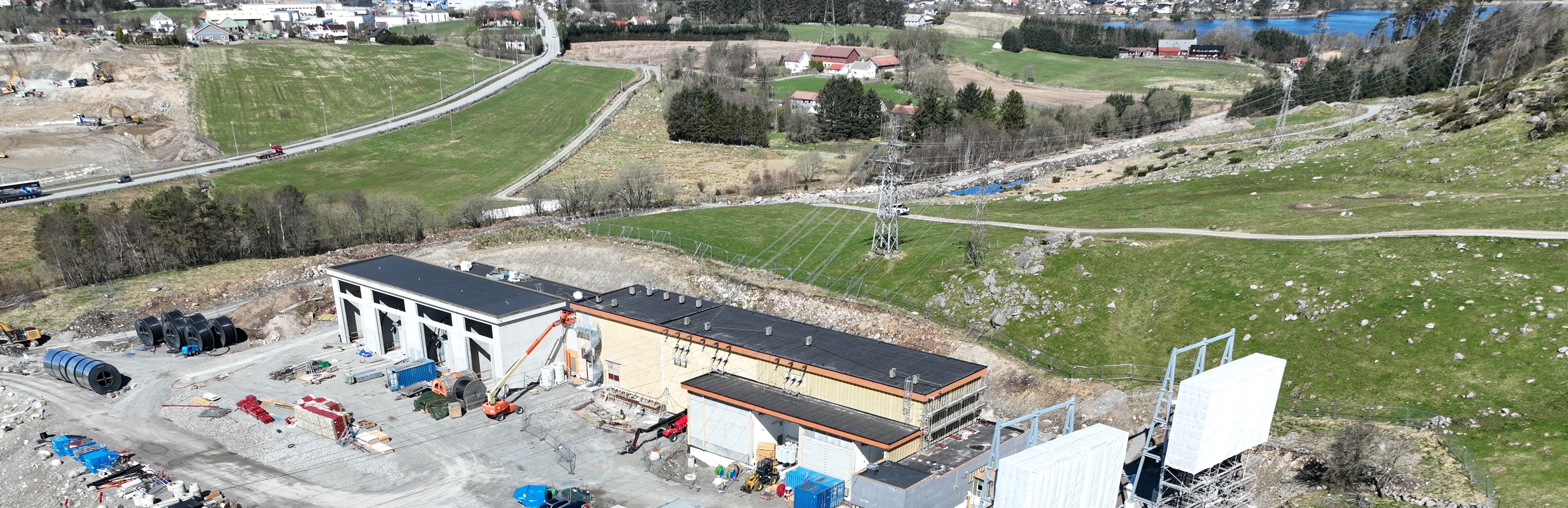Dronefoto som viser nytt påbygg med transformatornisjer til venstre og den gamle delen til høyre. 
